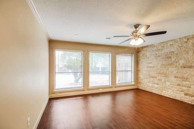 unfurnished room with dark wood-type flooring, ceiling fan, crown molding, and a textured ceiling