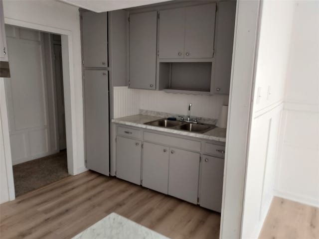 kitchen featuring gray cabinets, light wood-type flooring, and sink