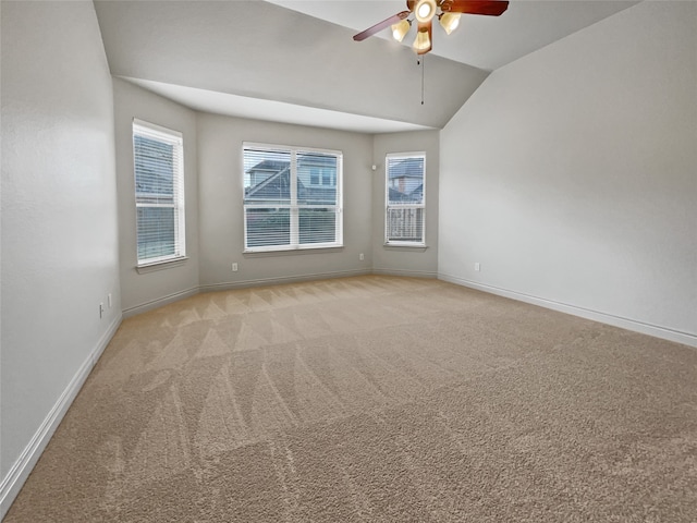 empty room with ceiling fan, light carpet, vaulted ceiling, and plenty of natural light