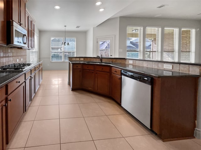 kitchen featuring decorative light fixtures, light tile floors, tasteful backsplash, and stainless steel appliances