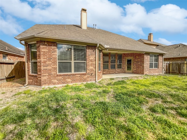 back of property featuring a yard and a patio area