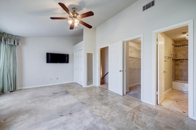 unfurnished bedroom with ceiling fan, lofted ceiling, ensuite bathroom, and light tile floors