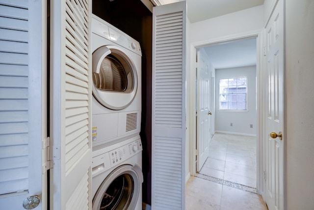 laundry room with stacked washer and clothes dryer and light tile floors