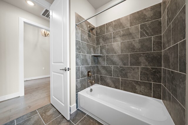 bathroom featuring wood-type flooring and tiled shower / bath combo