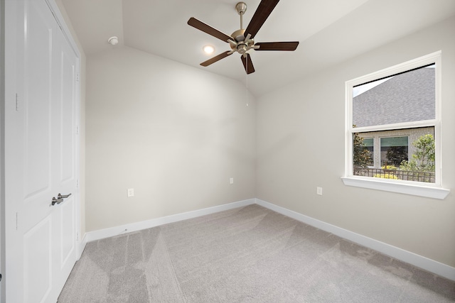 carpeted empty room with ceiling fan and lofted ceiling