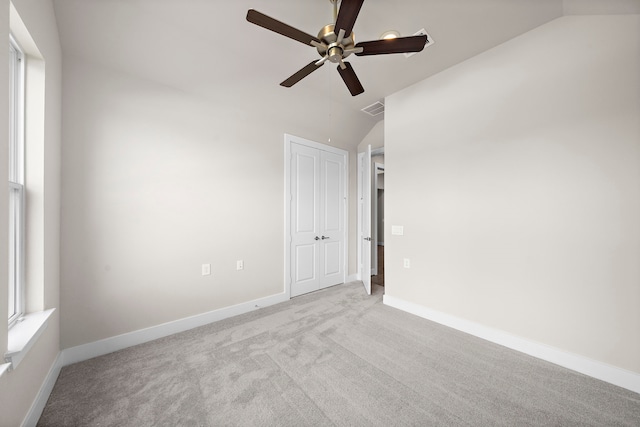 unfurnished room with lofted ceiling, ceiling fan, and light colored carpet