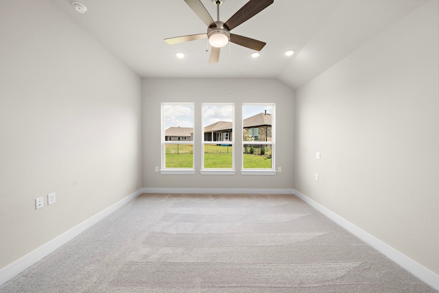 carpeted spare room with ceiling fan and vaulted ceiling