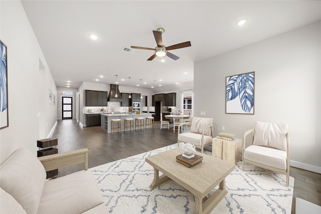 living room featuring ceiling fan and dark hardwood / wood-style flooring