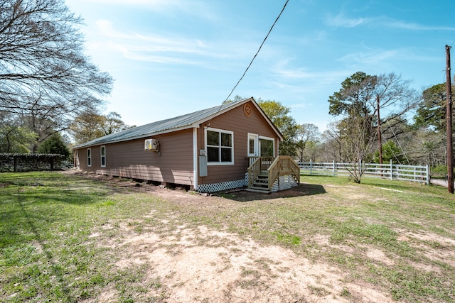 rear view of property featuring a lawn