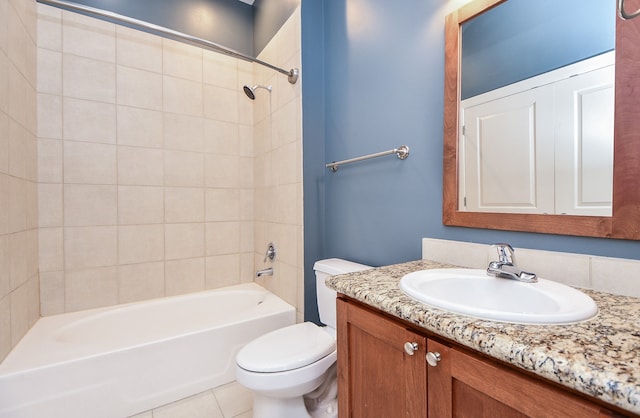 full bathroom featuring tiled shower / bath, toilet, tile flooring, and vanity