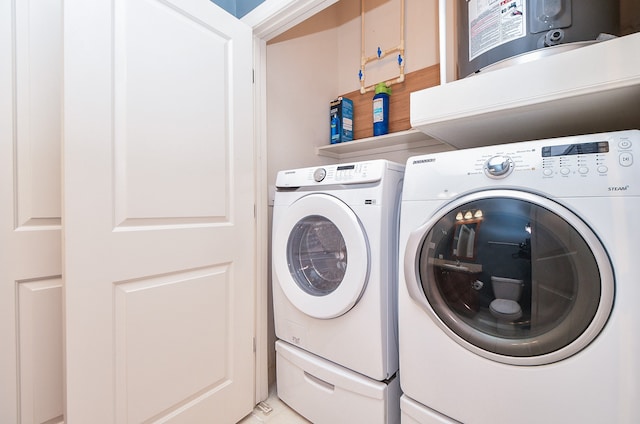 clothes washing area featuring water heater and washing machine and clothes dryer