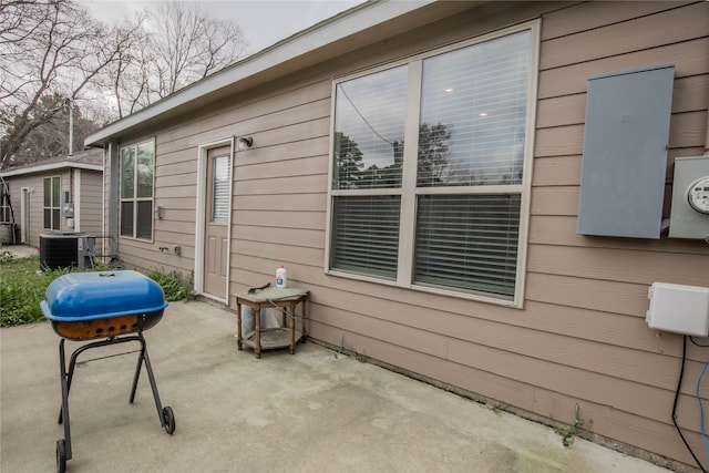 view of side of home featuring cooling unit and a patio area