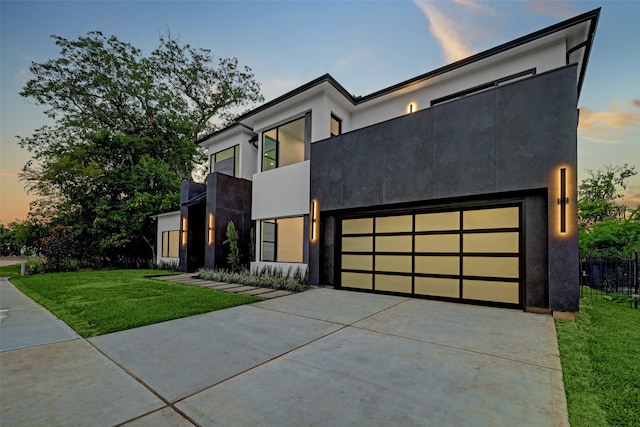 contemporary home with a garage and a yard