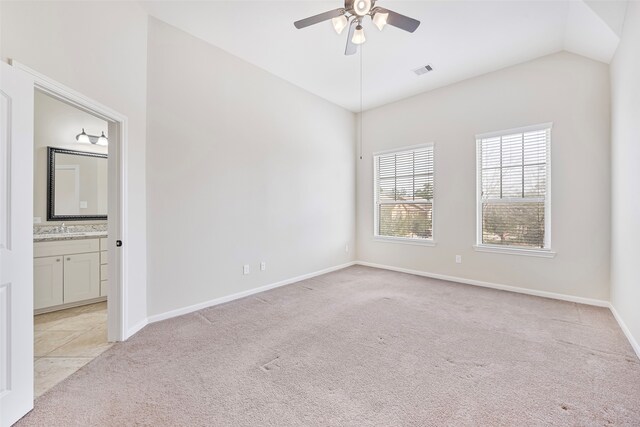 empty room featuring light carpet, vaulted ceiling, ceiling fan, and sink