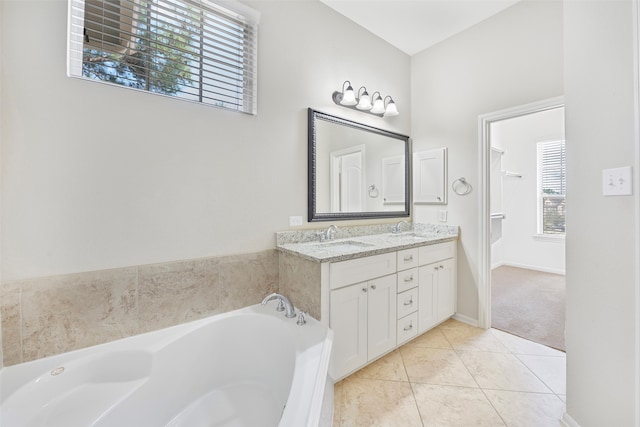 bathroom featuring tile flooring, double sink vanity, a bathing tub, and a healthy amount of sunlight