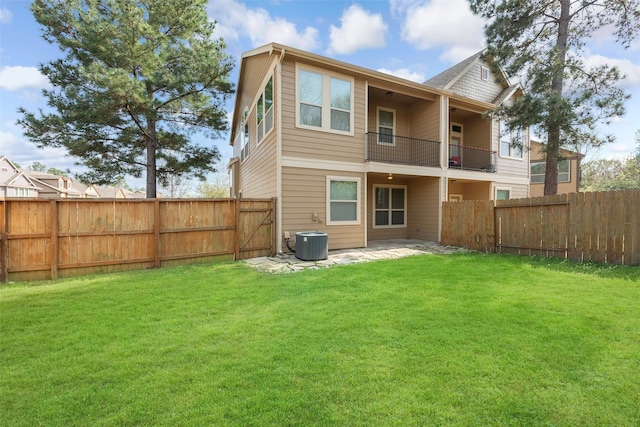 rear view of property with a balcony, a patio area, a lawn, and central AC unit