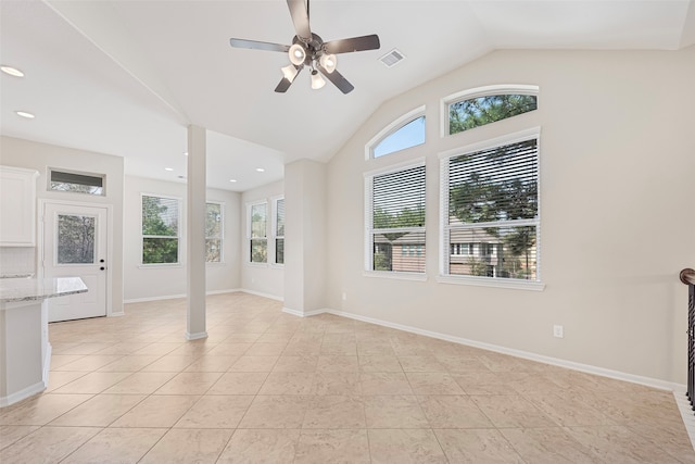 spare room featuring light tile flooring, ceiling fan, and vaulted ceiling