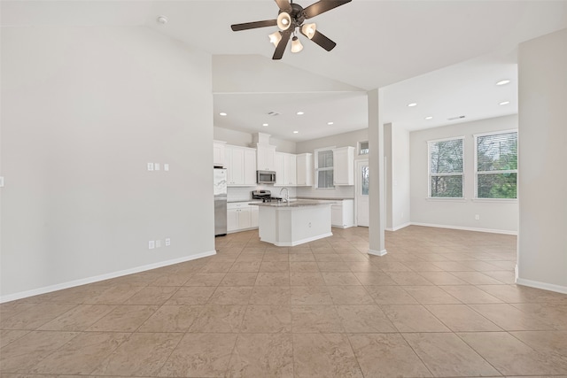 kitchen with a kitchen island with sink, white cabinetry, light tile floors, and stainless steel appliances