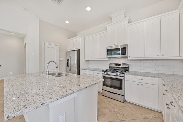 kitchen featuring backsplash, appliances with stainless steel finishes, sink, an island with sink, and white cabinets