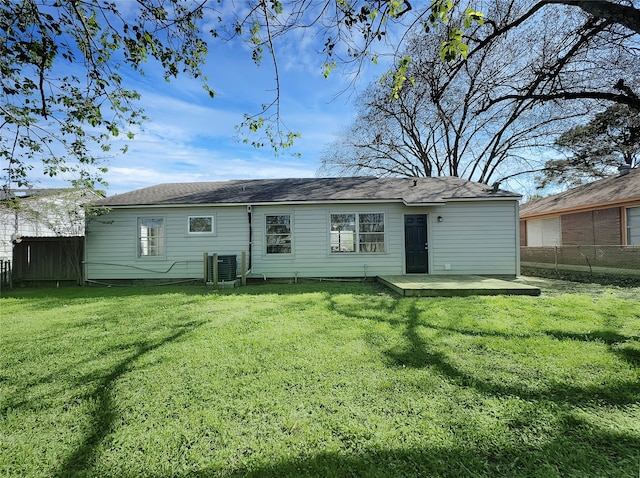 rear view of property featuring a yard and central air condition unit