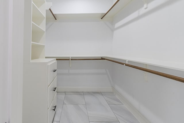 walk in closet with light tile patterned floors