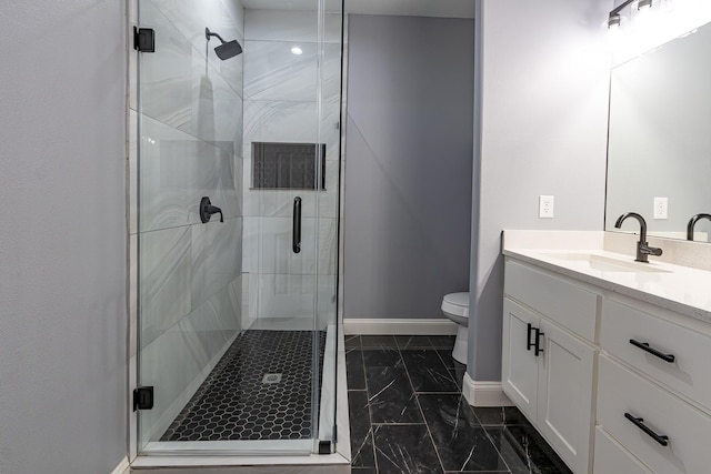 bathroom featuring a shower with door, vanity, and toilet