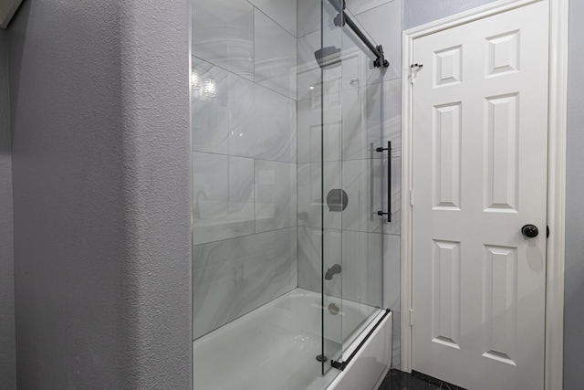 bathroom featuring combined bath / shower with glass door