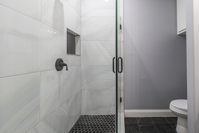 bathroom featuring toilet and an enclosed shower