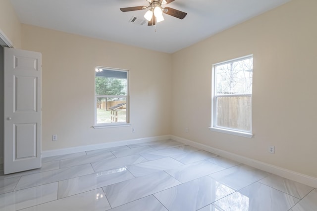 tiled empty room featuring ceiling fan