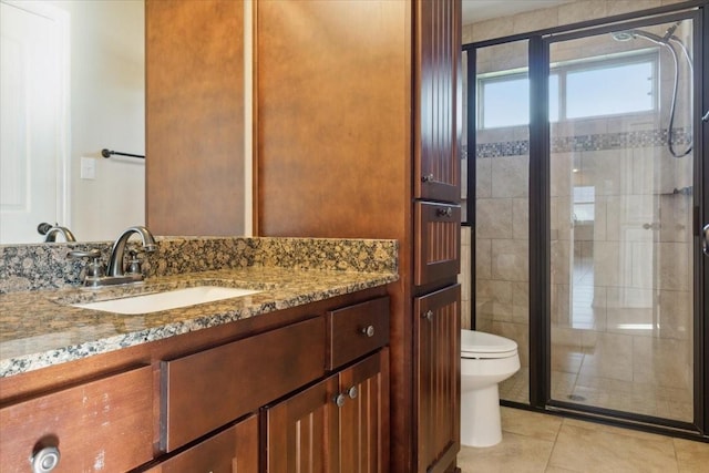 bathroom with tile patterned floors, toilet, vanity, and walk in shower