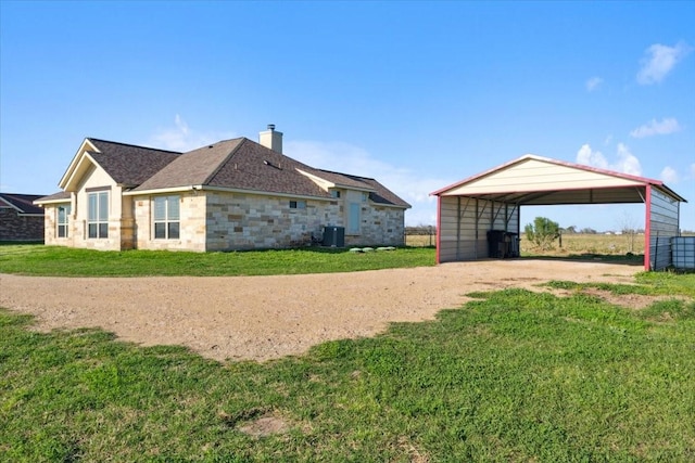 exterior space featuring a lawn, cooling unit, and a carport