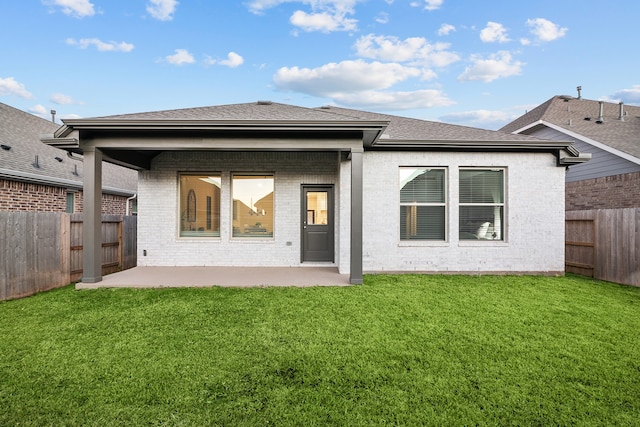 rear view of property with a yard and a patio