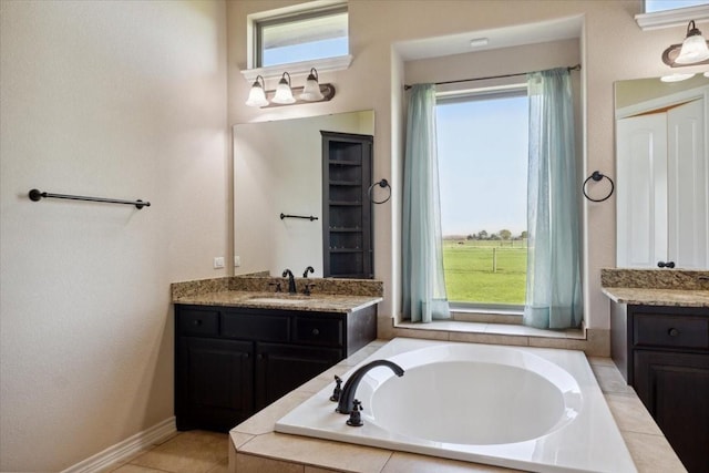 bathroom featuring vanity, a wealth of natural light, and tiled tub