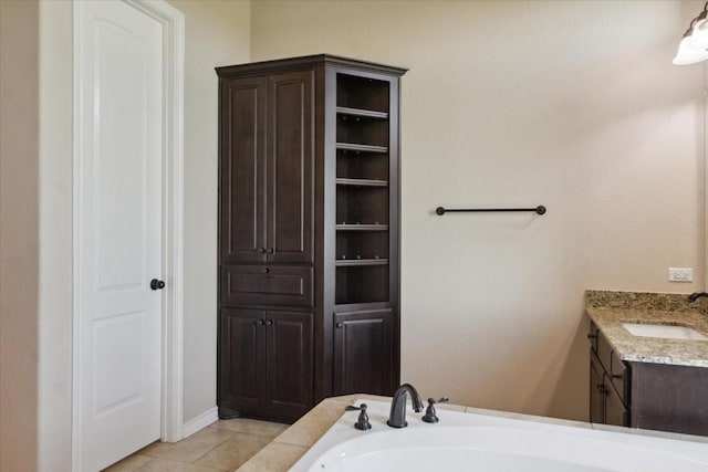 bathroom featuring tile patterned flooring, vanity, and a tub to relax in