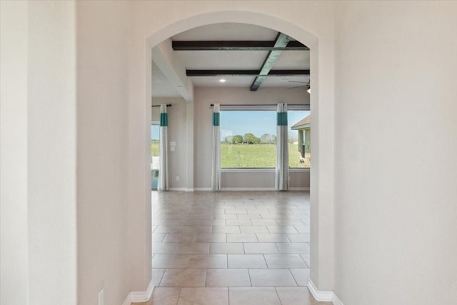 hallway with beamed ceiling, light tile patterned flooring, and coffered ceiling