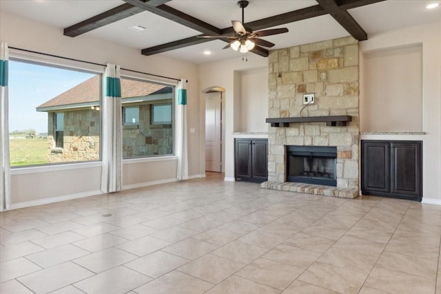 unfurnished living room with beam ceiling, a stone fireplace, ceiling fan, and coffered ceiling