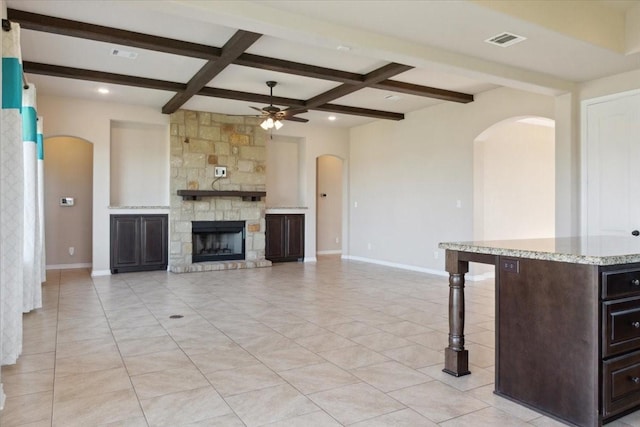 unfurnished living room featuring a fireplace, beam ceiling, ceiling fan, and coffered ceiling