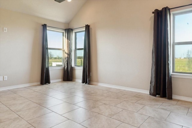 empty room featuring light tile patterned flooring and vaulted ceiling