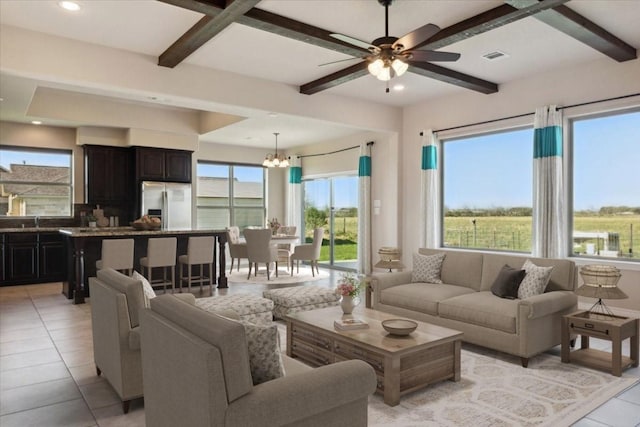 living room featuring beam ceiling, sink, light tile patterned floors, and ceiling fan with notable chandelier