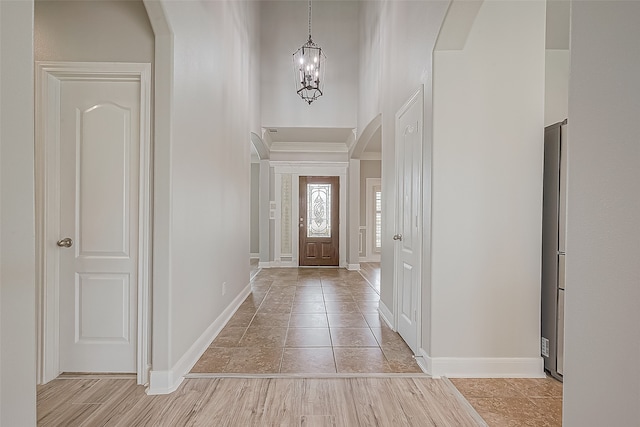 foyer with light tile flooring and a notable chandelier