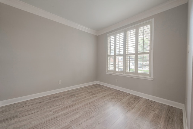 unfurnished room featuring ornamental molding and light hardwood / wood-style flooring