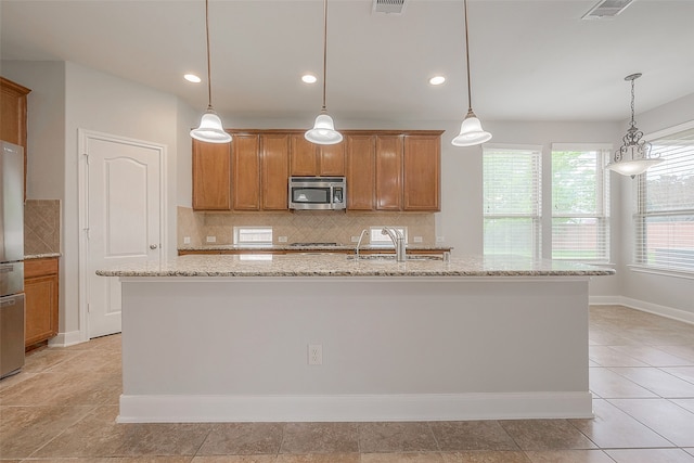 kitchen featuring hanging light fixtures, stainless steel appliances, and light tile floors