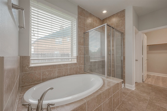 bathroom featuring tile flooring and separate shower and tub