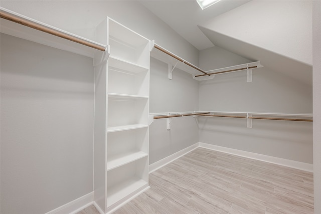 walk in closet with light hardwood / wood-style flooring