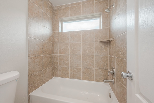 bathroom with tiled shower / bath combo and toilet