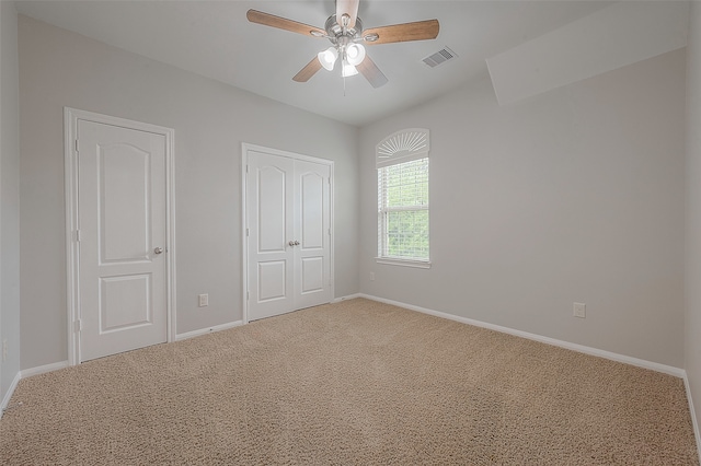 unfurnished bedroom featuring light colored carpet and ceiling fan