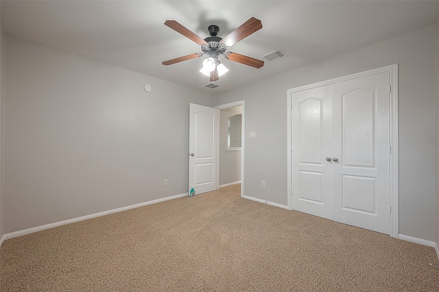 unfurnished bedroom featuring light colored carpet, a closet, and ceiling fan