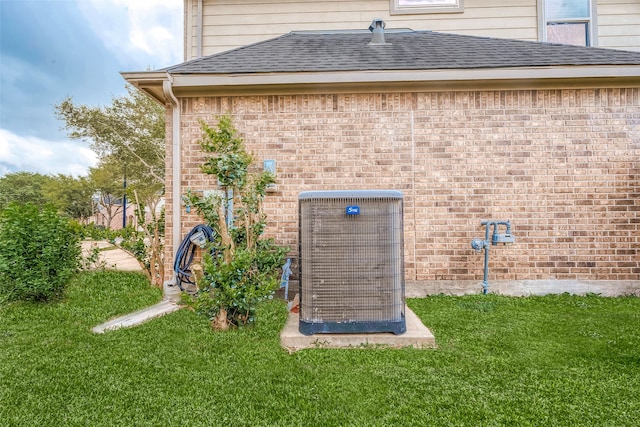 view of outdoor structure featuring central AC and a yard