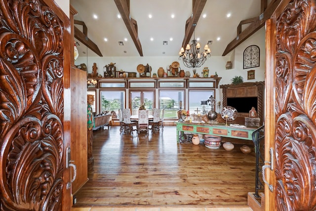 interior space featuring hardwood / wood-style flooring, an inviting chandelier, and lofted ceiling with beams