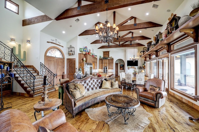 living room with a healthy amount of sunlight, a chandelier, and light wood-type flooring